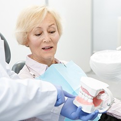 dentist showing a set of dentures to a patient