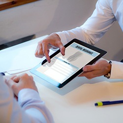 person filling out dental insurance forms on a tablet