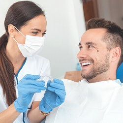 Dentist and patient smiling while discussing Invisalign