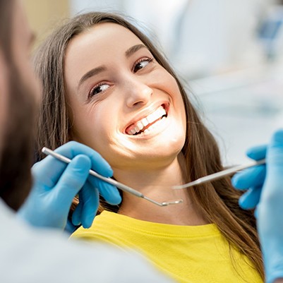 Woman smiling at dentist while in treatment chair
