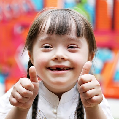 Little girl giving thumbs up after special needs dentistry appointment