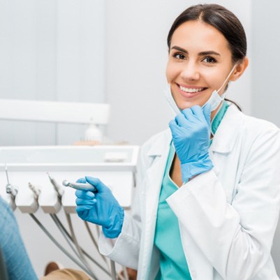 Female dentist smiling at patient's dental exam