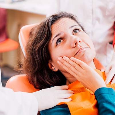 Pained woman visiting her Carrollton emergency dentist 