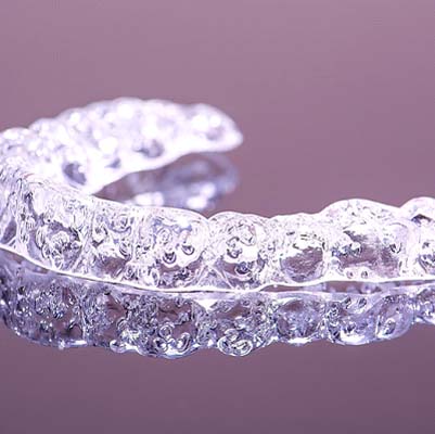 Close up of clear aligner with purple background